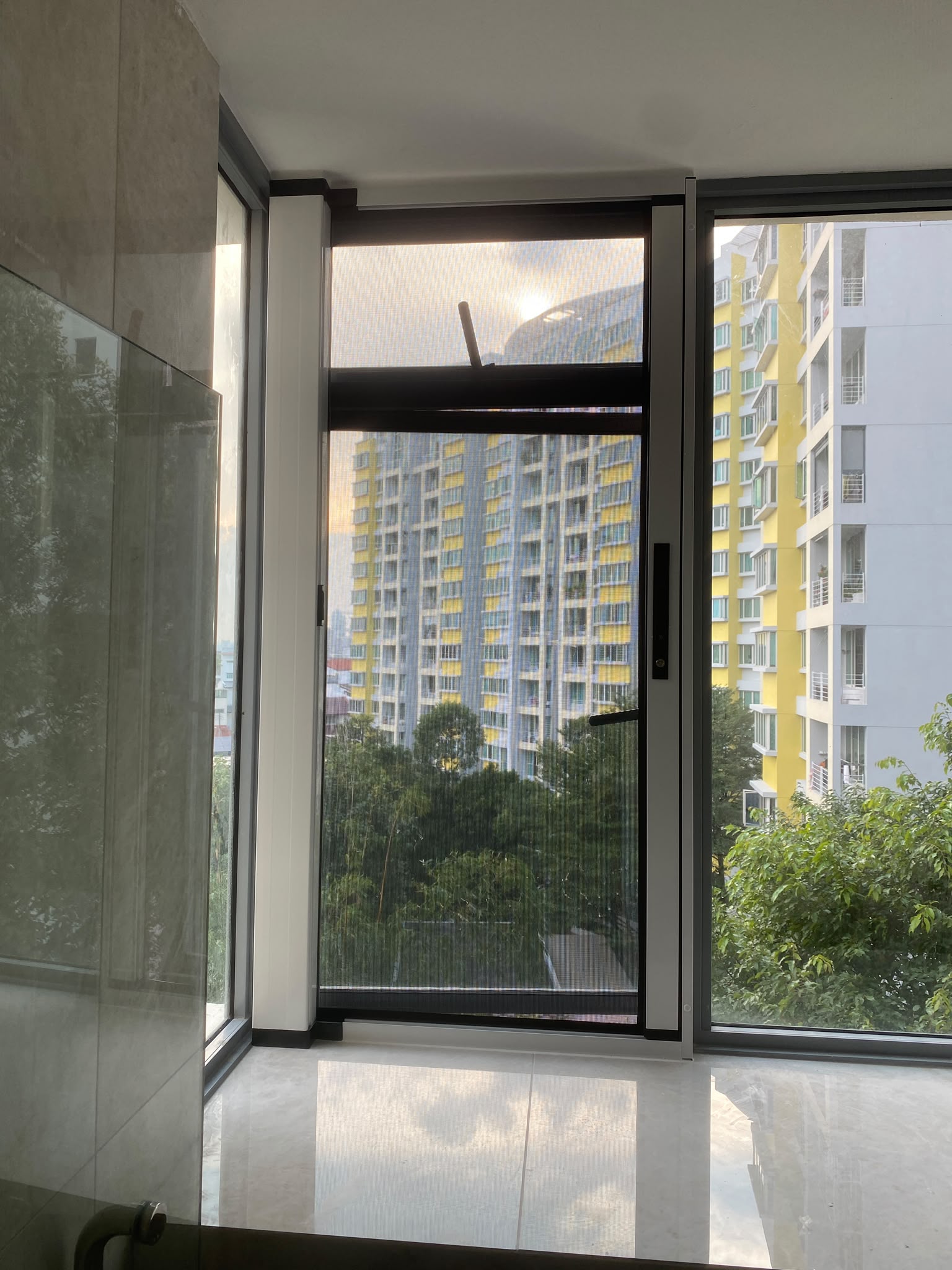 PurrSafe mesh fitted to a tall side window in a high-rise Singapore home
